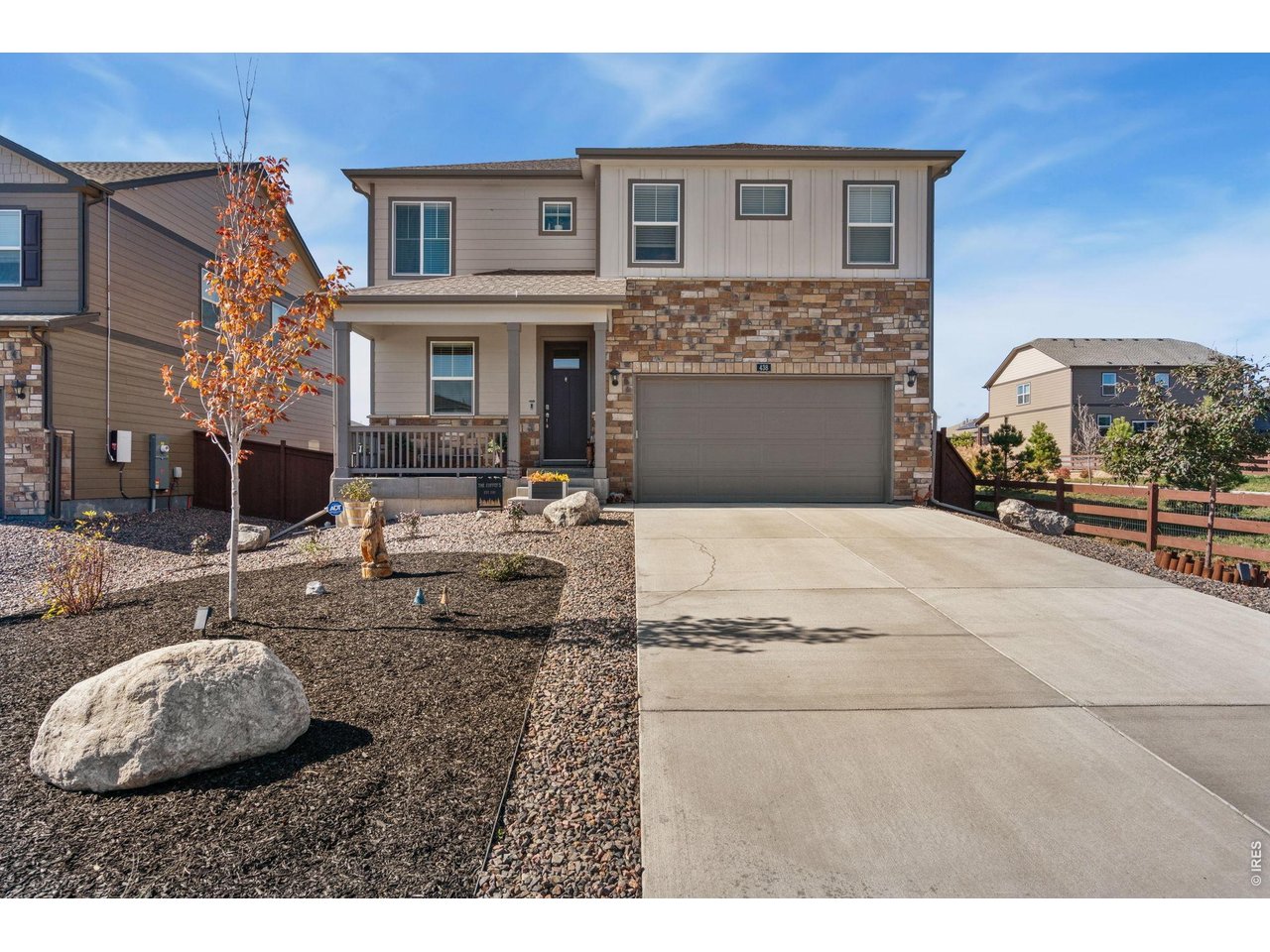 438 Bluebird Road Johnstown, CO 80534 - Photo 6 of 33 Curb view with extended concrete driveway, covered entry, and tidy rock landscaping.