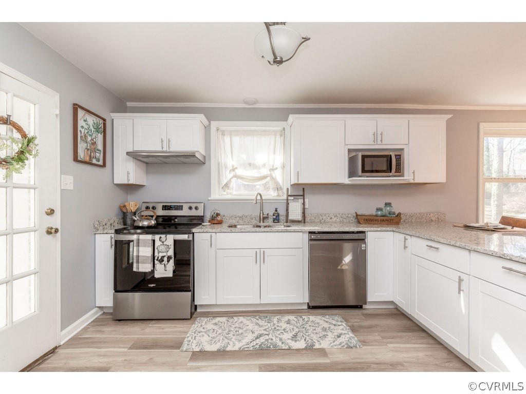 8541 Elm Road Richmond, VA 23235 - Photo 15 of 50 a kitchen with a stove a sink and a microwave