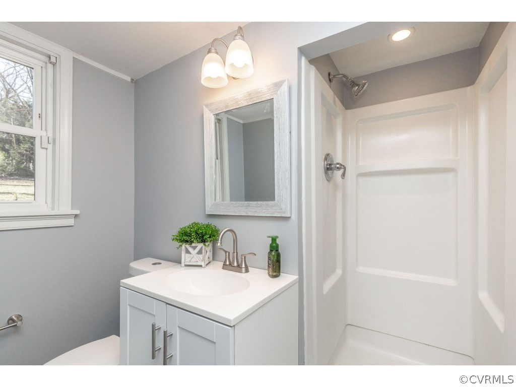 8541 Elm Road Richmond, VA 23235 - Photo 44 of 50 a bathroom with a sink a mirror and a shower