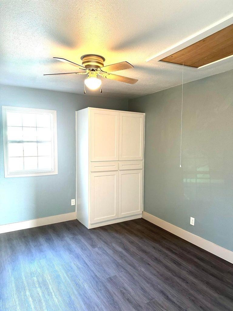 1704 West 6th Plainview, TX 79072 - Photo 11 of 13 an empty room with wooden floor and windows
