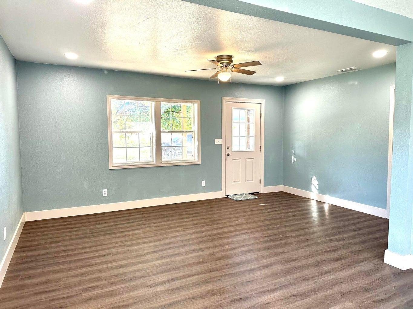 1704 West 6th Plainview, TX 79072 - Photo 2 of 13 a view of an empty room with wooden floor and a window