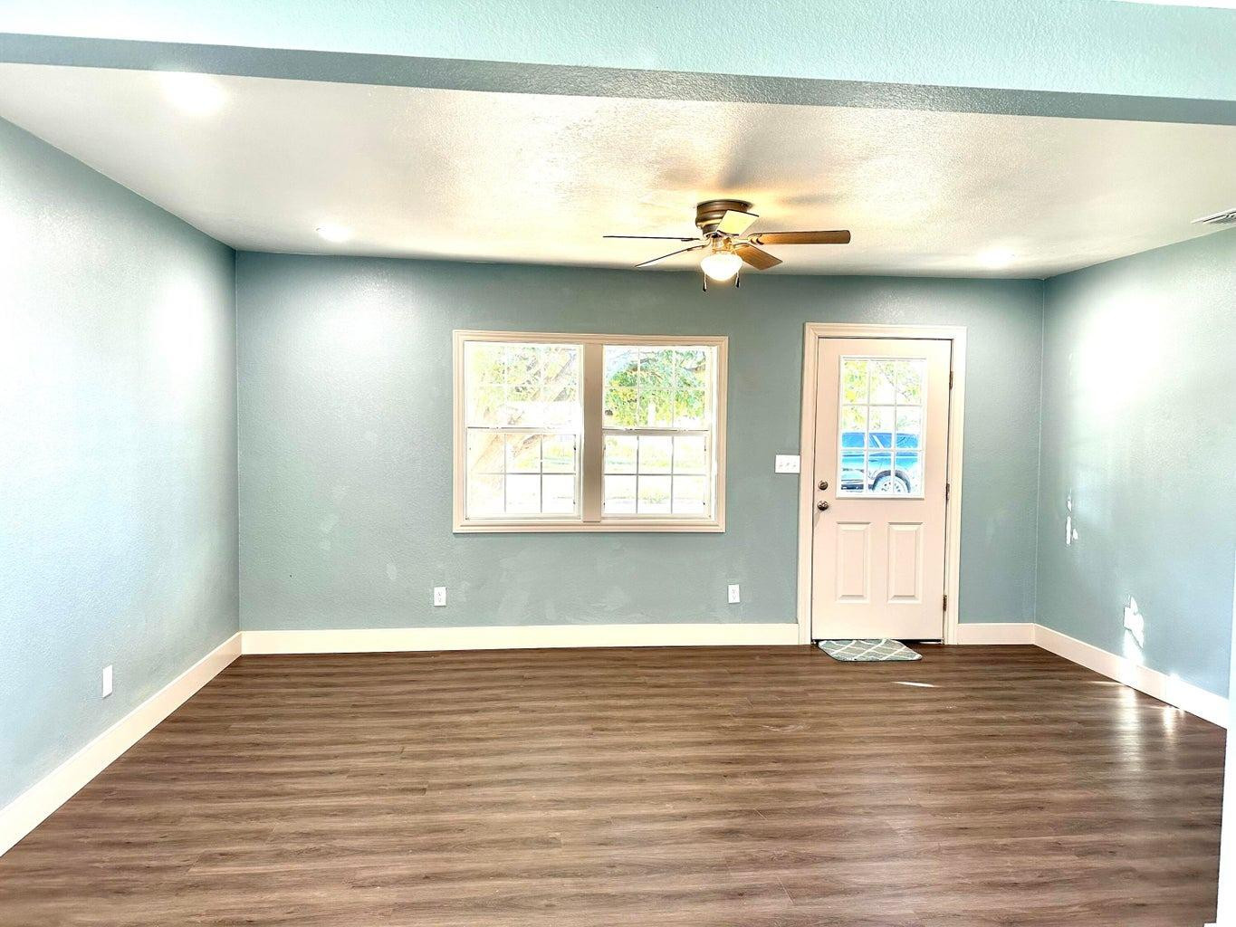 1704 West 6th Plainview, TX 79072 - Photo 3 of 13 a view of empty room with wooden floor and fan