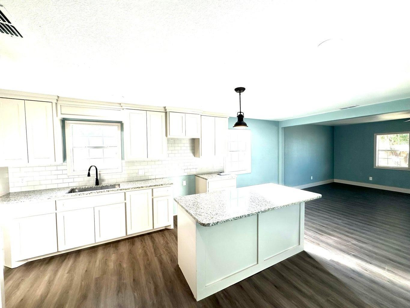 1704 West 6th Plainview, TX 79072 - Photo 4 of 13 a kitchen with a sink cabinets and wooden floor