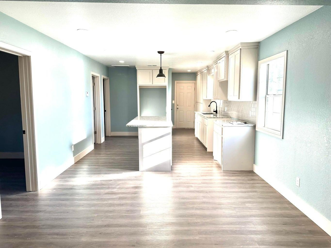 1704 West 6th Plainview, TX 79072 - Photo 5 of 13 a view of a kitchen with kitchen island a sink wooden floor and living room