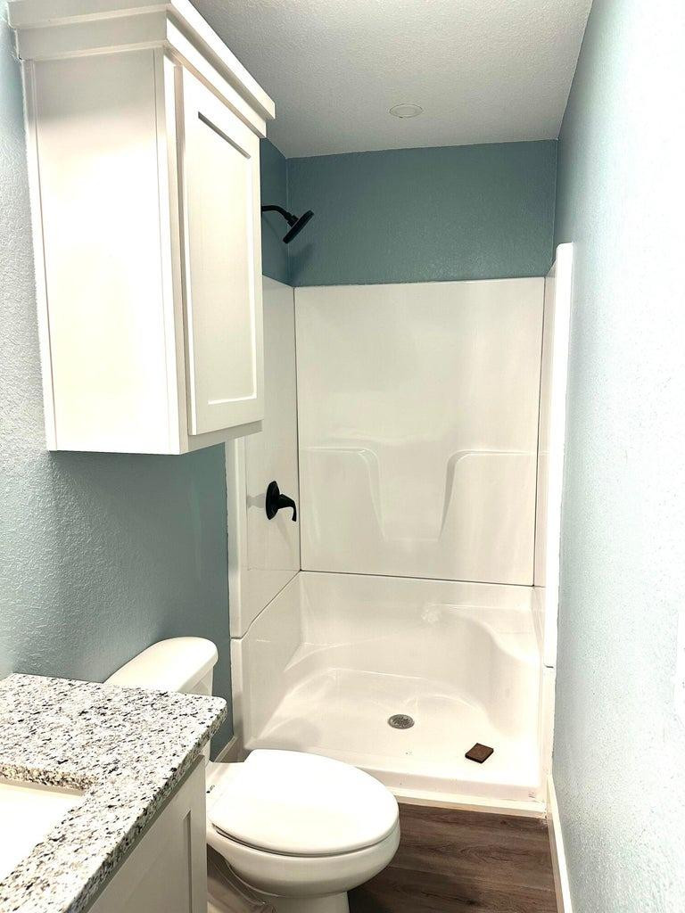 1704 West 6th Plainview, TX 79072 - Photo 7 of 13 a bathroom with a granite countertop bathtub sink vanity and toilet