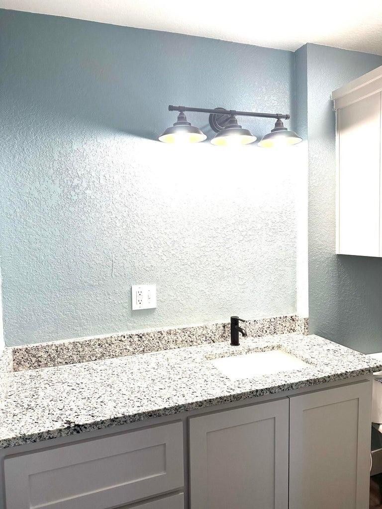 1704 West 6th Plainview, TX 79072 - Photo 10 of 13 a bathroom with a granite countertop sink and a mirror