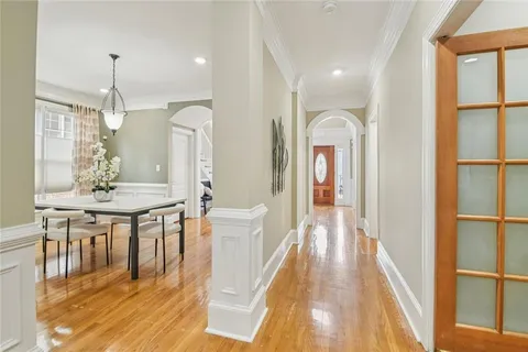 a view of a hallway with wooden floor windows and chandelier