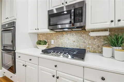 a kitchen with stainless steel appliances a white stove top oven and cabinets
