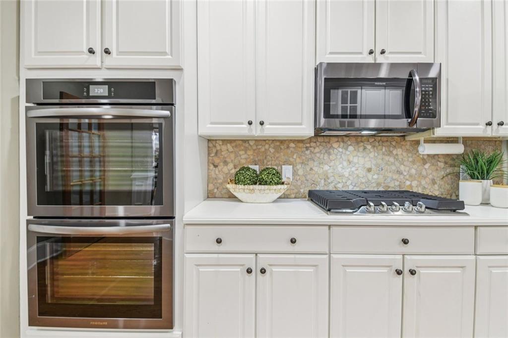 121 Fulton Way Southeast Atlanta, GA 30312 - Photo 19 of 38 a kitchen with granite countertop white cabinets and stainless steel appliances