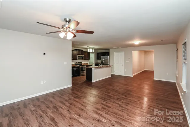 a view of kitchen with wooden floor and a ceiling fan