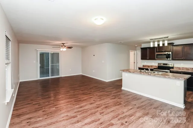 a view of kitchen with wooden floor and electronic appliances
