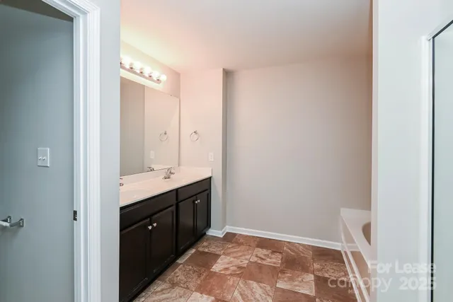 a spacious bathroom with a granite countertop sink and a mirror