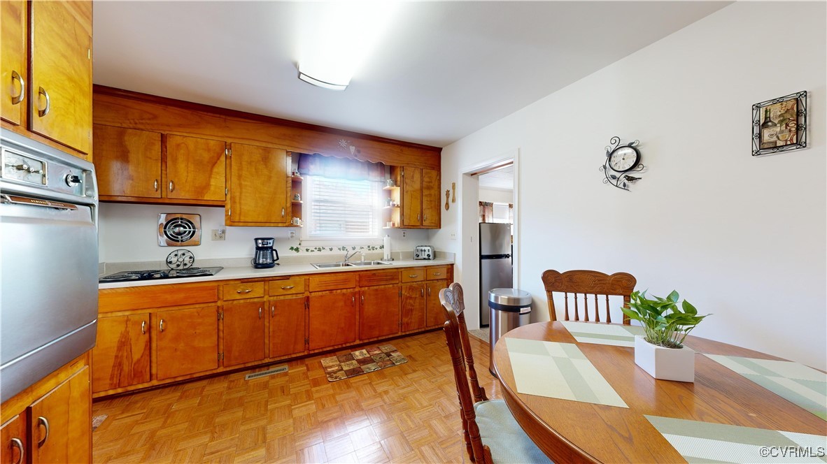 706 James Avenue Colonial Heights, VA 23834 - Photo 8 of 14 a large kitchen with stainless steel appliances granite countertop a sink a stove a dining table and chairs with wooden floor