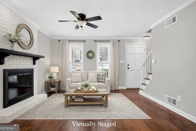 a view of an empty room with wooden floor fireplace and a window