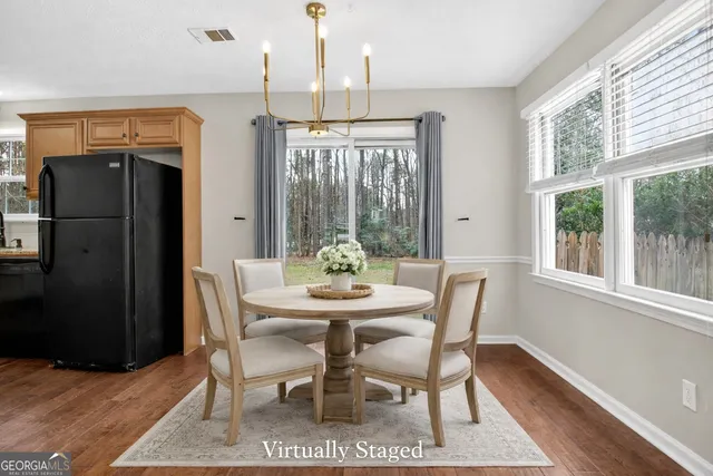 a view of an empty room with window and chandelier