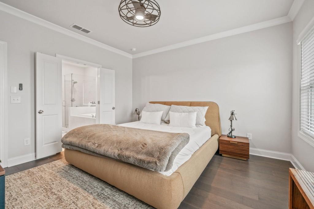 5217 Riden Court, Unit 263 Buford, GA 30518 - Photo 20 of 34 a bedroom with a bed and a chandelier