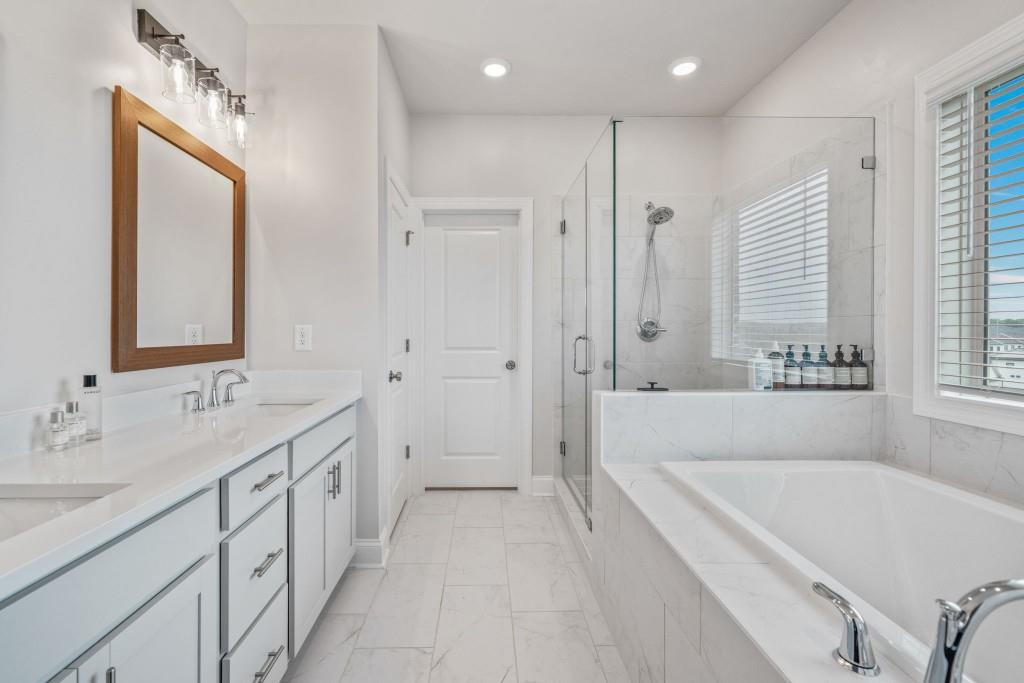 5217 Riden Court, Unit 263 Buford, GA 30518 - Photo 23 of 34 a spacious bathroom with a tub sink and mirror