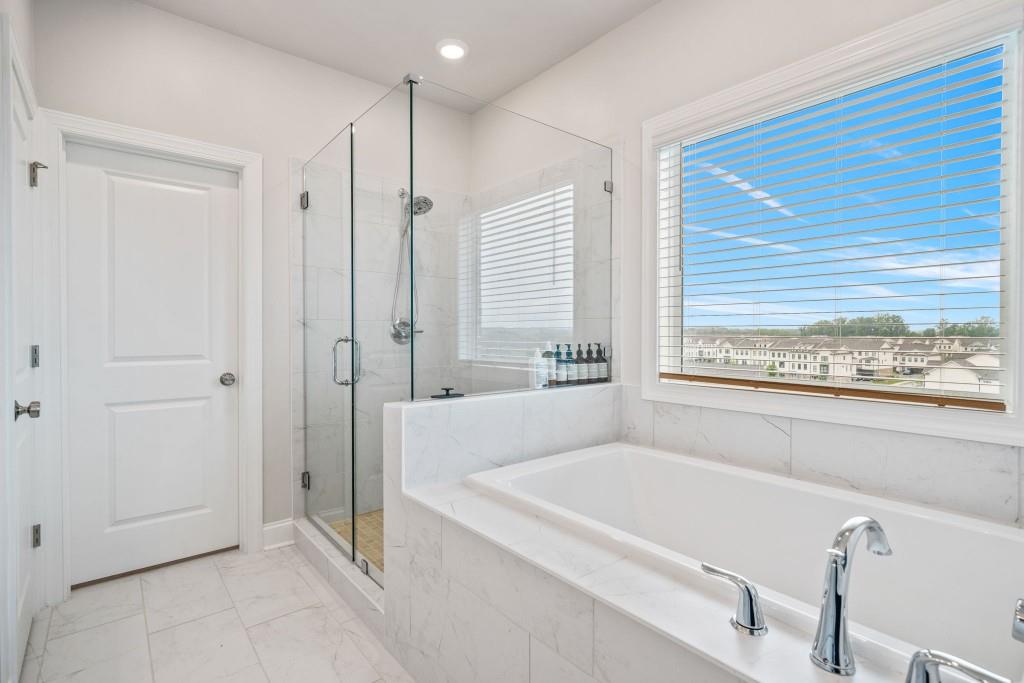 5217 Riden Court, Unit 263 Buford, GA 30518 - Photo 25 of 34 a bathroom with a large tub a shower and view