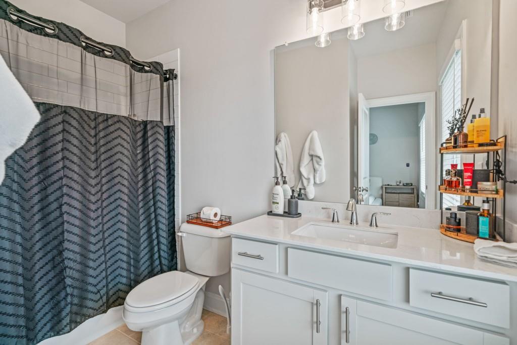 5217 Riden Court, Unit 263 Buford, GA 30518 - Photo 28 of 34 a bathroom with a sink mirror vanity and toilet