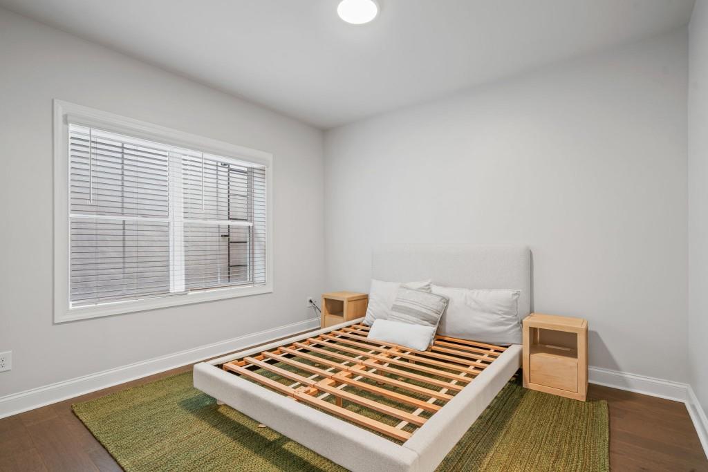 5217 Riden Court, Unit 263 Buford, GA 30518 - Photo 29 of 34 a bedroom with a bed and wooden floor
