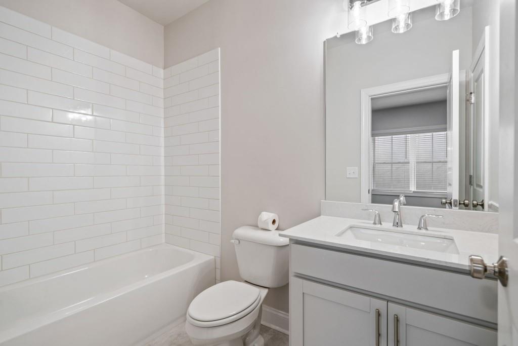 5217 Riden Court, Unit 263 Buford, GA 30518 - Photo 30 of 34 a bathroom with a sink a toilet and shower