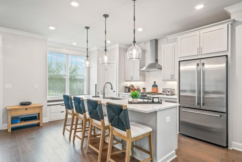 5217 Riden Court, Unit 263 Buford, GA 30518 - Photo 5 of 34 a kitchen with stainless steel appliances a dining table chairs stove and refrigerator