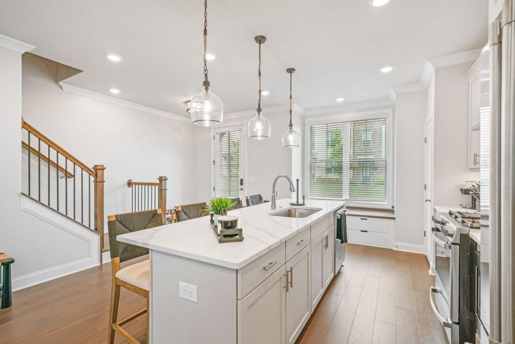 5217 Riden Court, Unit 263 Buford, GA 30518 - Photo 8 of 34 a view of a kitchen island a chandelier and wooden floor
