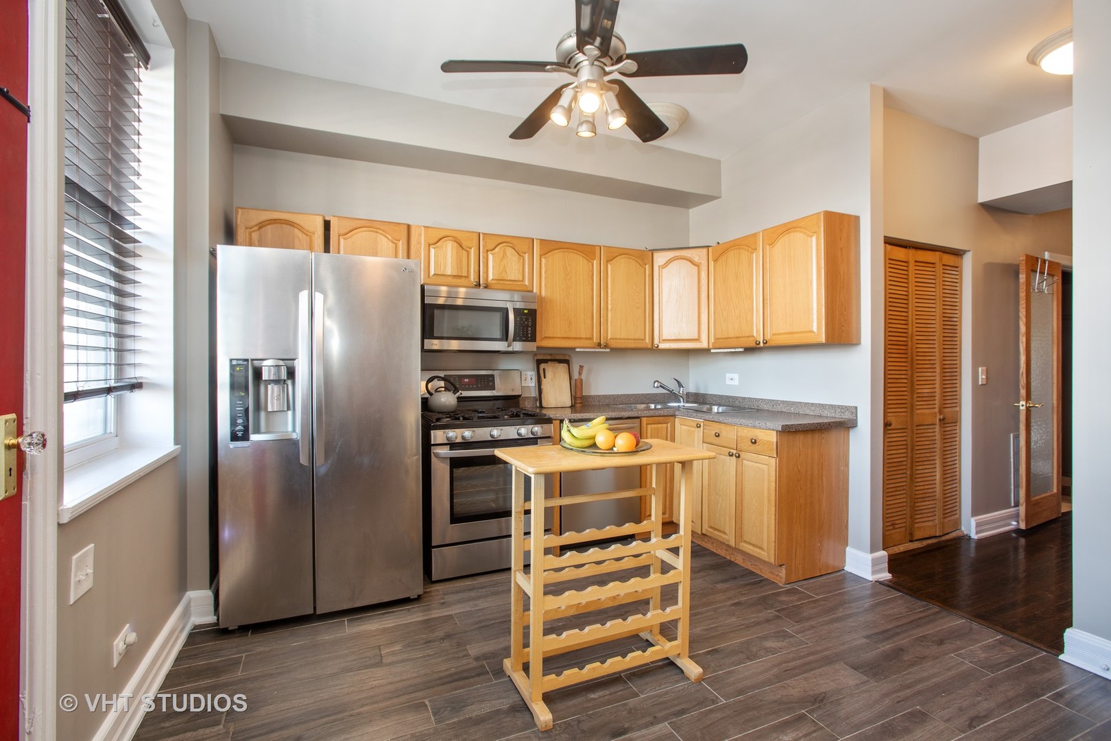 4631 South Indiana Avenue, Unit 3N Chicago, IL 60653 - Photo 4 of 11 a kitchen with granite countertop a refrigerator cabinets and wooden floor