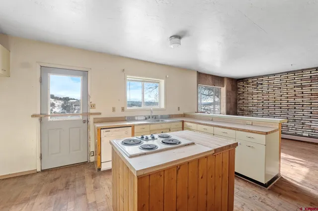 a kitchen with a sink cabinets and wooden floor