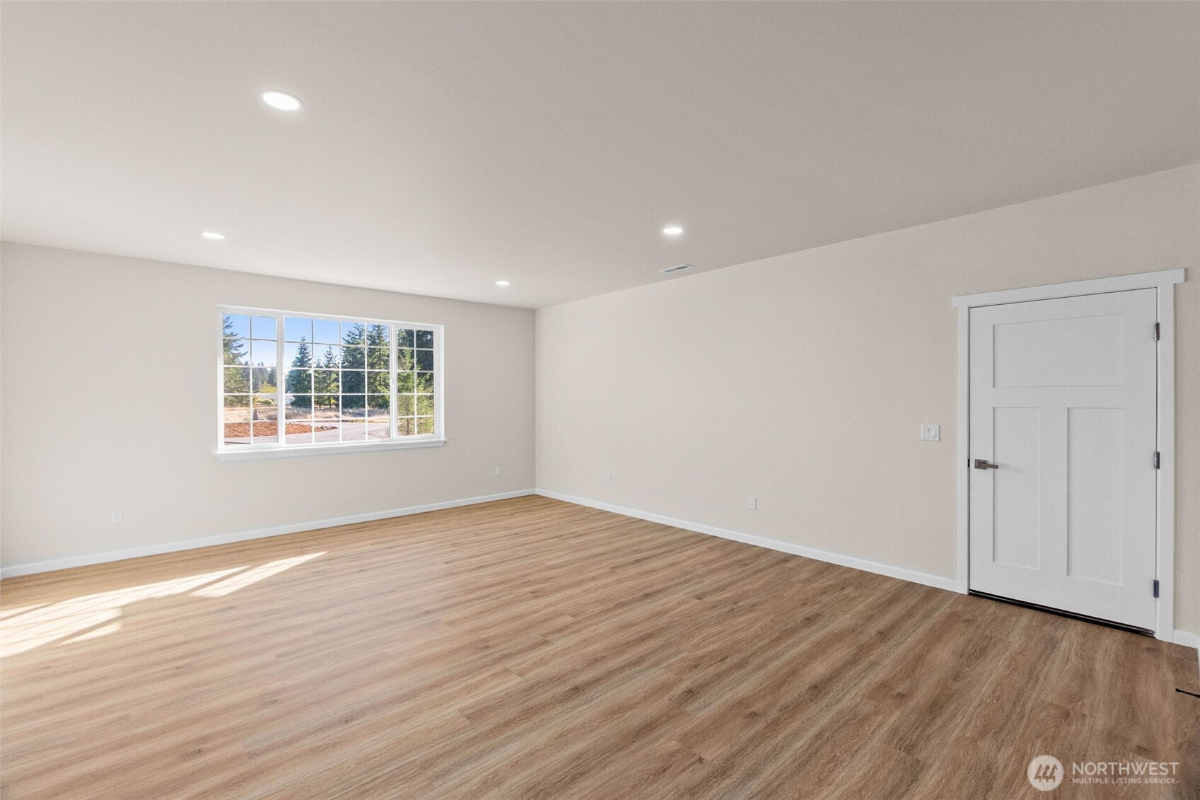 6123 186th Trail Southwest Rochester, WA 98579 - Photo 13 of 35 a view of an empty room with wooden floor and a window