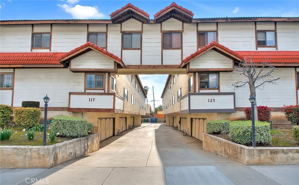 a front view of a house with a yard and potted plants