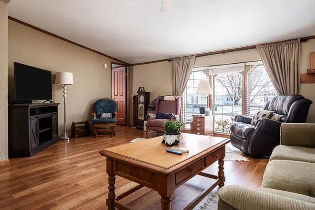a living room with furniture a flat screen tv and a large window