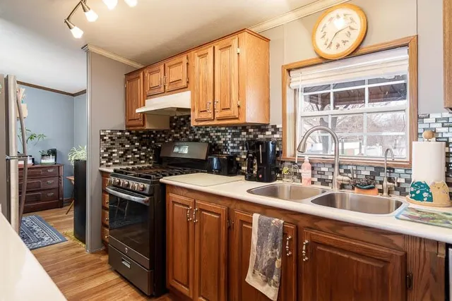 a kitchen with a stove a sink and a wooden cabinets