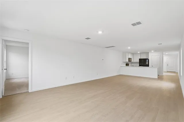 a view of empty room with kitchen