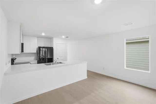 a kitchen with a sink and a stove with wooden floor
