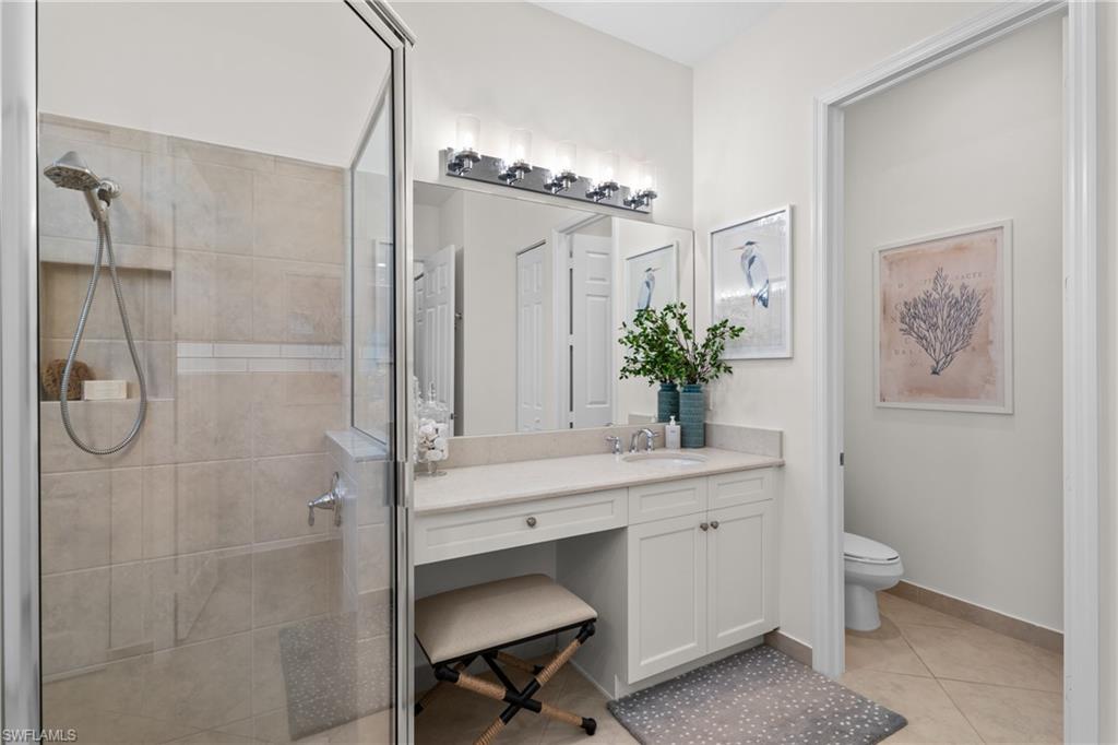 13459 Sumter Lane Naples, FL 34109 - Photo 16 of 40 a bathroom with a granite countertop sink a toilet and a mirror