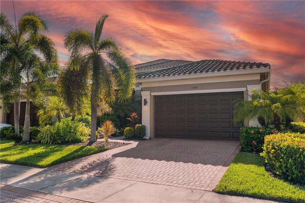 13459 Sumter Lane Naples, FL 34109 - Photo 2 of 40 a front view of a house with a yard and garage