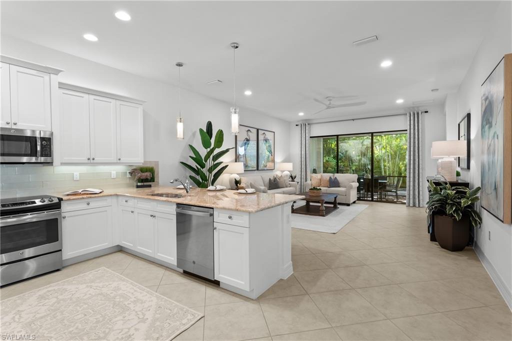 13459 Sumter Lane Naples, FL 34109 - Photo 7 of 40 a kitchen with a sink and white cabinets
