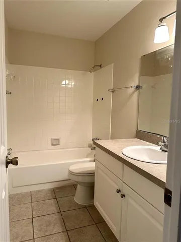 a bathroom with a granite countertop sink a toilet and shower