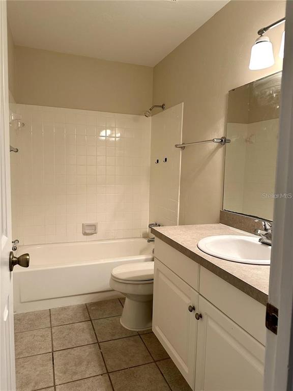501 Southwest 75th Street, Unit G1 Gainesville, FL 32607 - Photo 17 of 20 a bathroom with a granite countertop sink a toilet and shower
