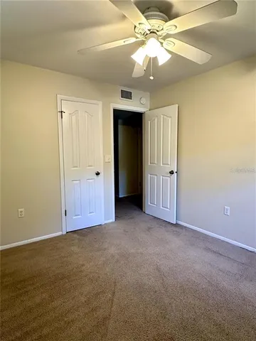 an empty room with a ceiling fan and a window