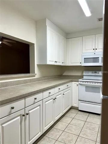 a kitchen with granite countertop white cabinets and stainless steel appliances