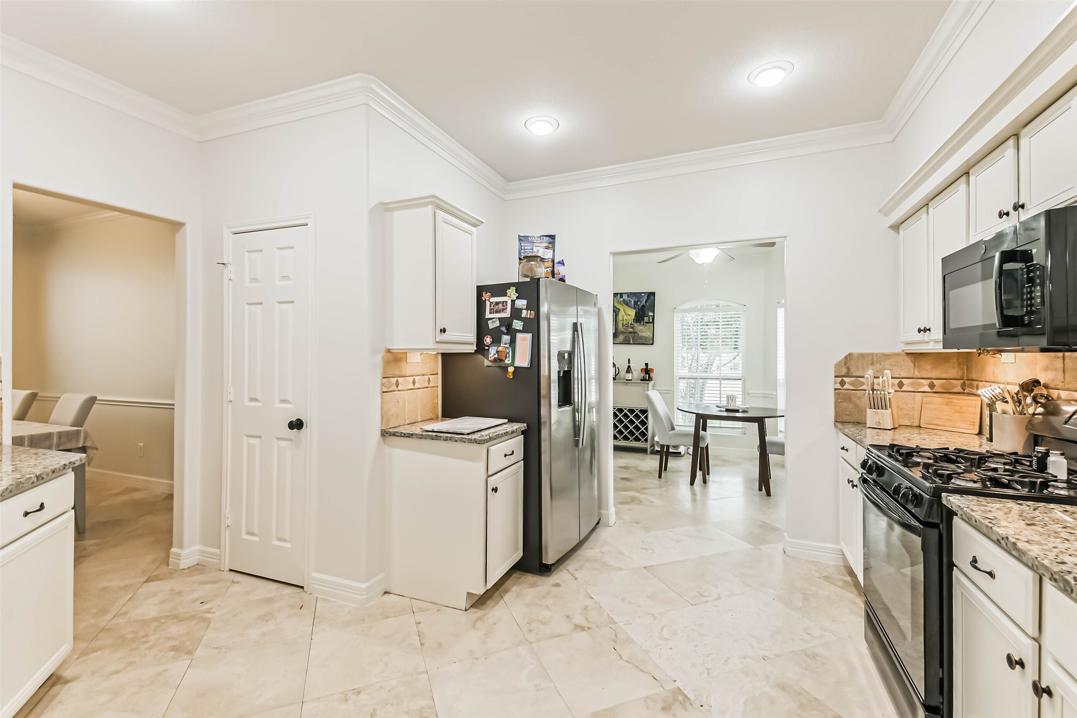 22538 Goss Spring Court Spring, TX 77373 - Photo 9 of 36 This kitchen features modern stainless steel appliances, granite countertops, and ample cabinetry. It opens to a dining area with a view through a wide doorway, offering a spacious and inviting atmosphere.