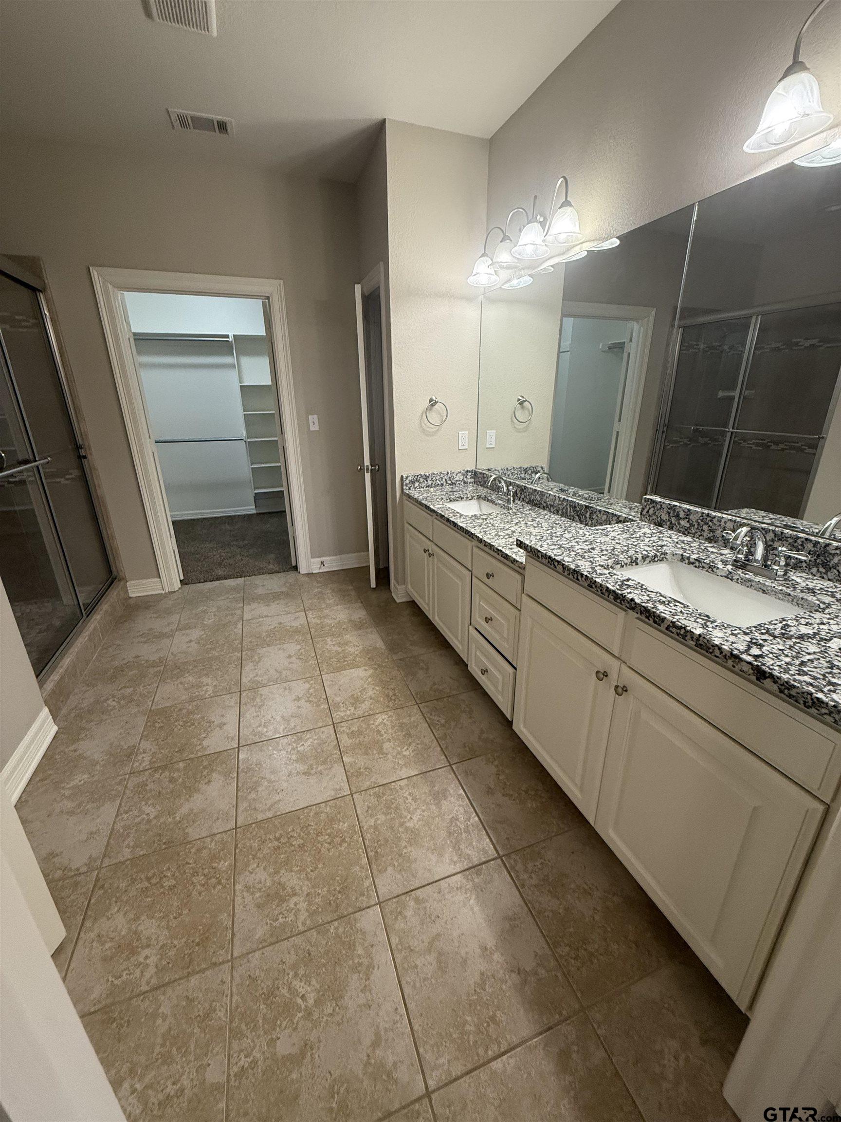 16440 County Road 178, Unit 1007 Tyler, TX 75703 - Photo 12 of 25 a large bathroom with a sink and a mirror