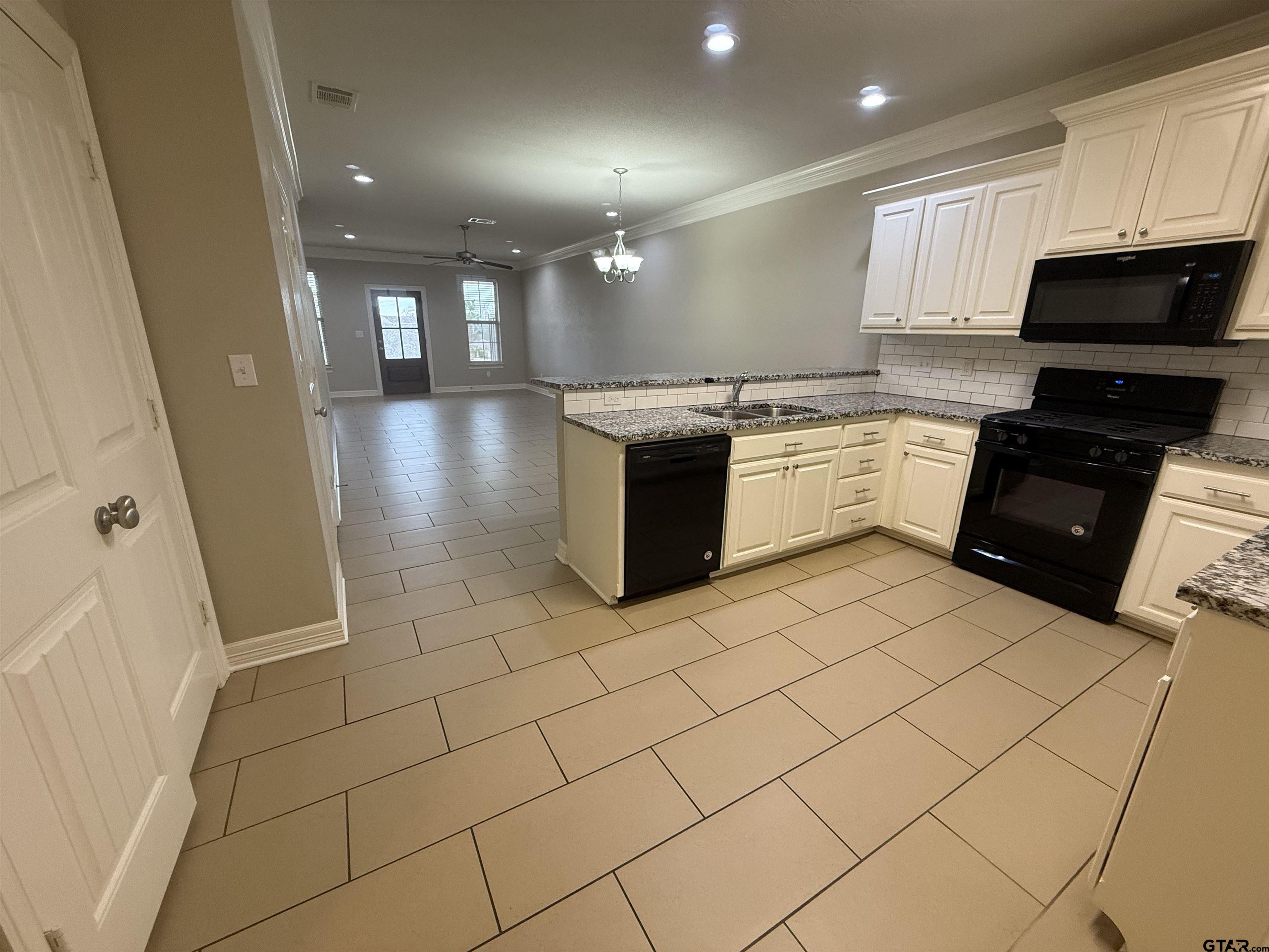 16440 County Road 178, Unit 1007 Tyler, TX 75703 - Photo 5 of 25 a large kitchen with a sink and cabinets