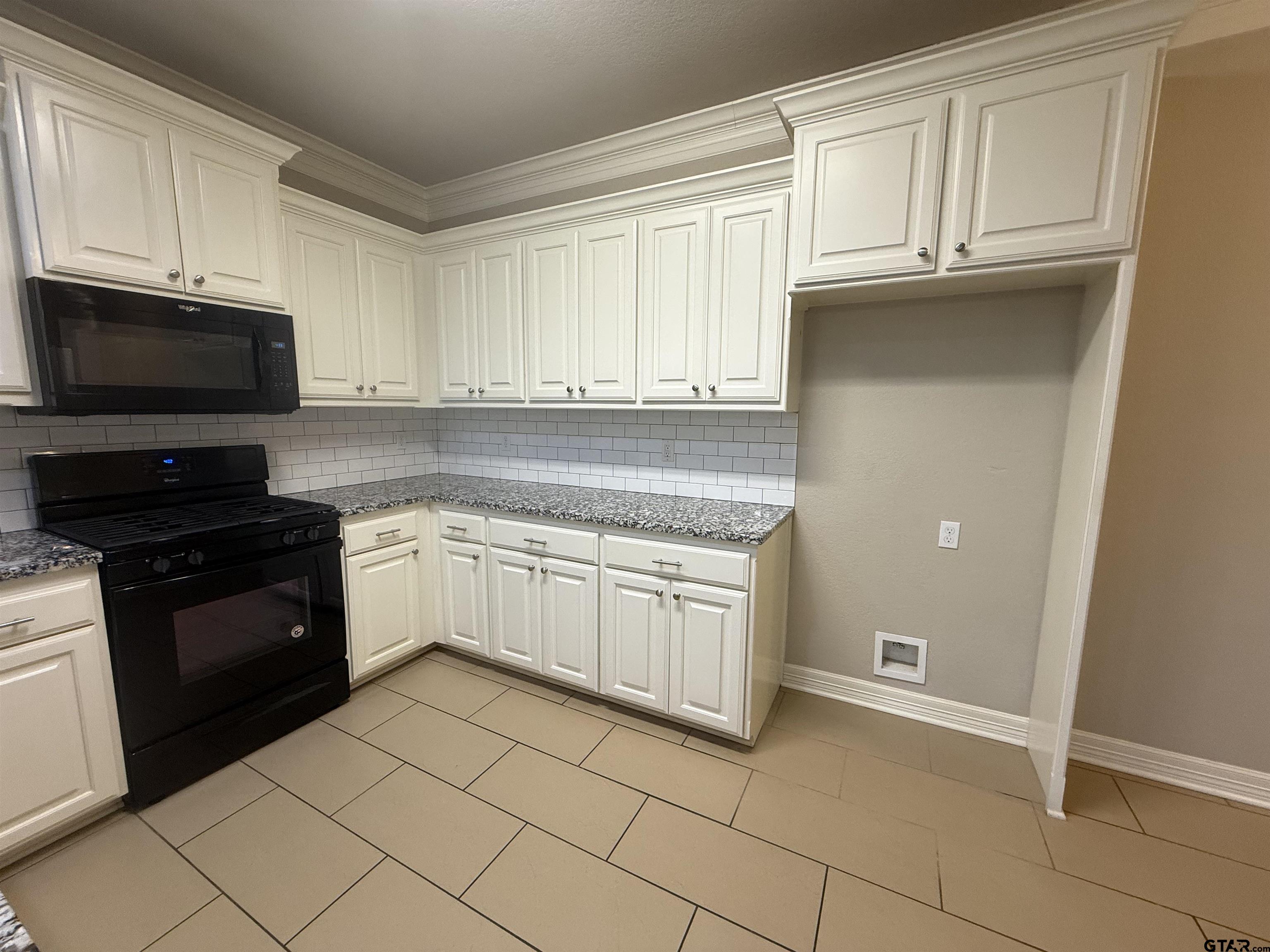 16440 County Road 178, Unit 1007 Tyler, TX 75703 - Photo 7 of 25 a kitchen with granite countertop white cabinets and stainless steel appliances