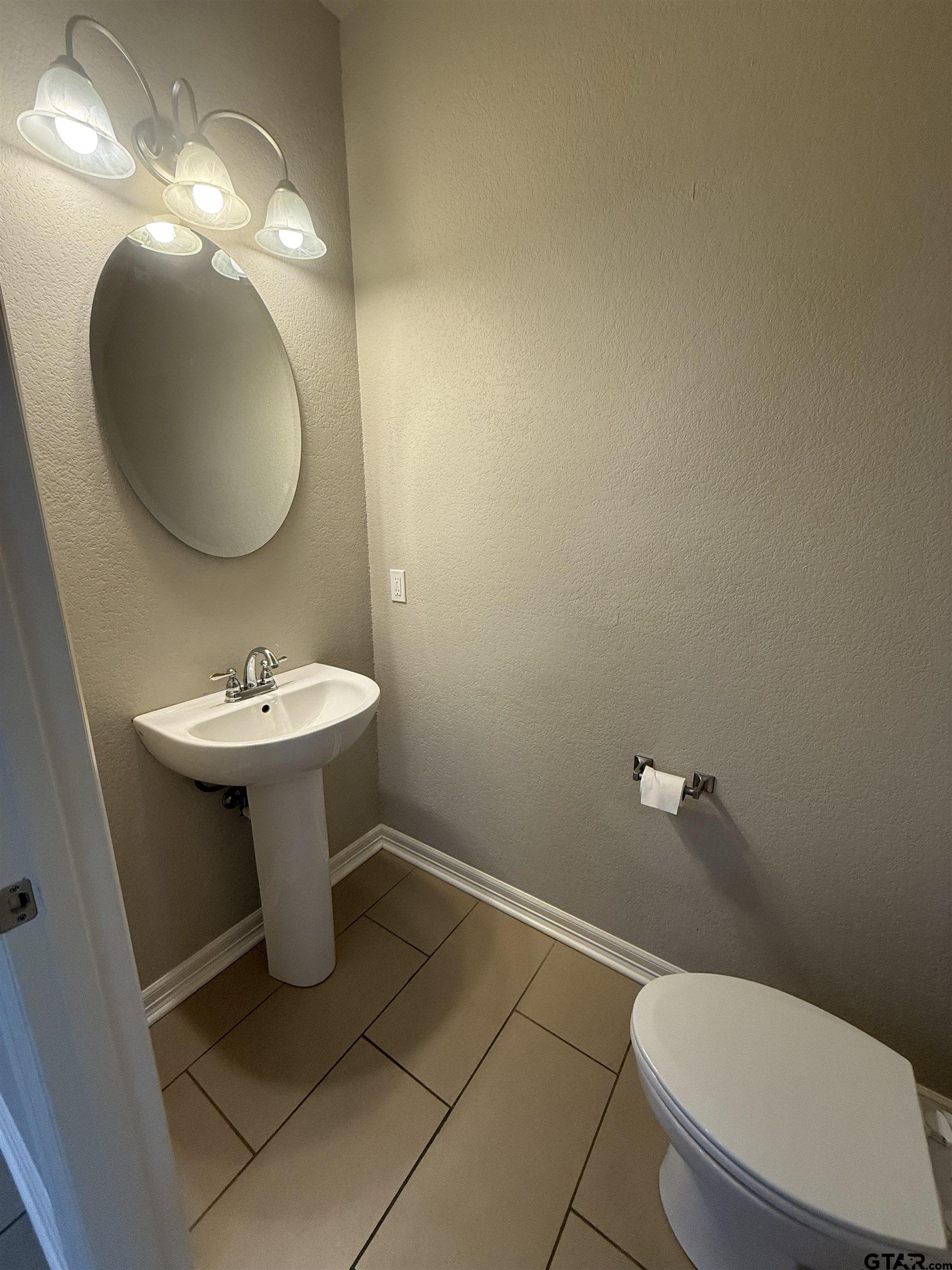 16440 County Road 178, Unit 1007 Tyler, TX 75703 - Photo 9 of 25 a bathroom with a toilet sink and mirror