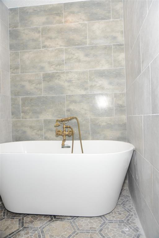 14333 Preston Road, Unit 1704 Dallas, TX 75254 - Photo 14 of 15 Freestanding white soaking tub with a vintage-style brass faucet