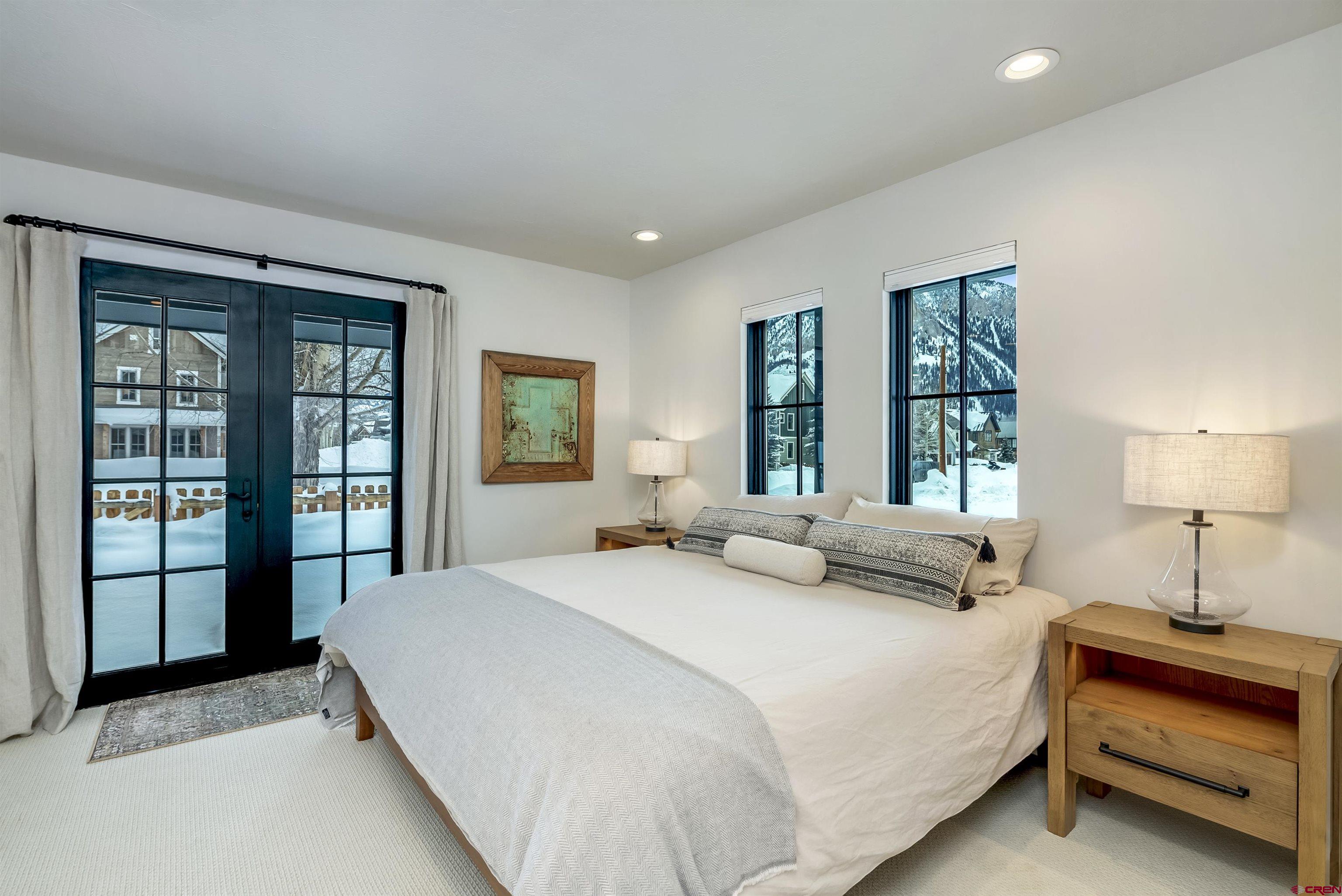 705 9th Street Crested Butte, CO 81224 - Photo 27 of 44 a bedroom with a large bed and a lamp next to a window