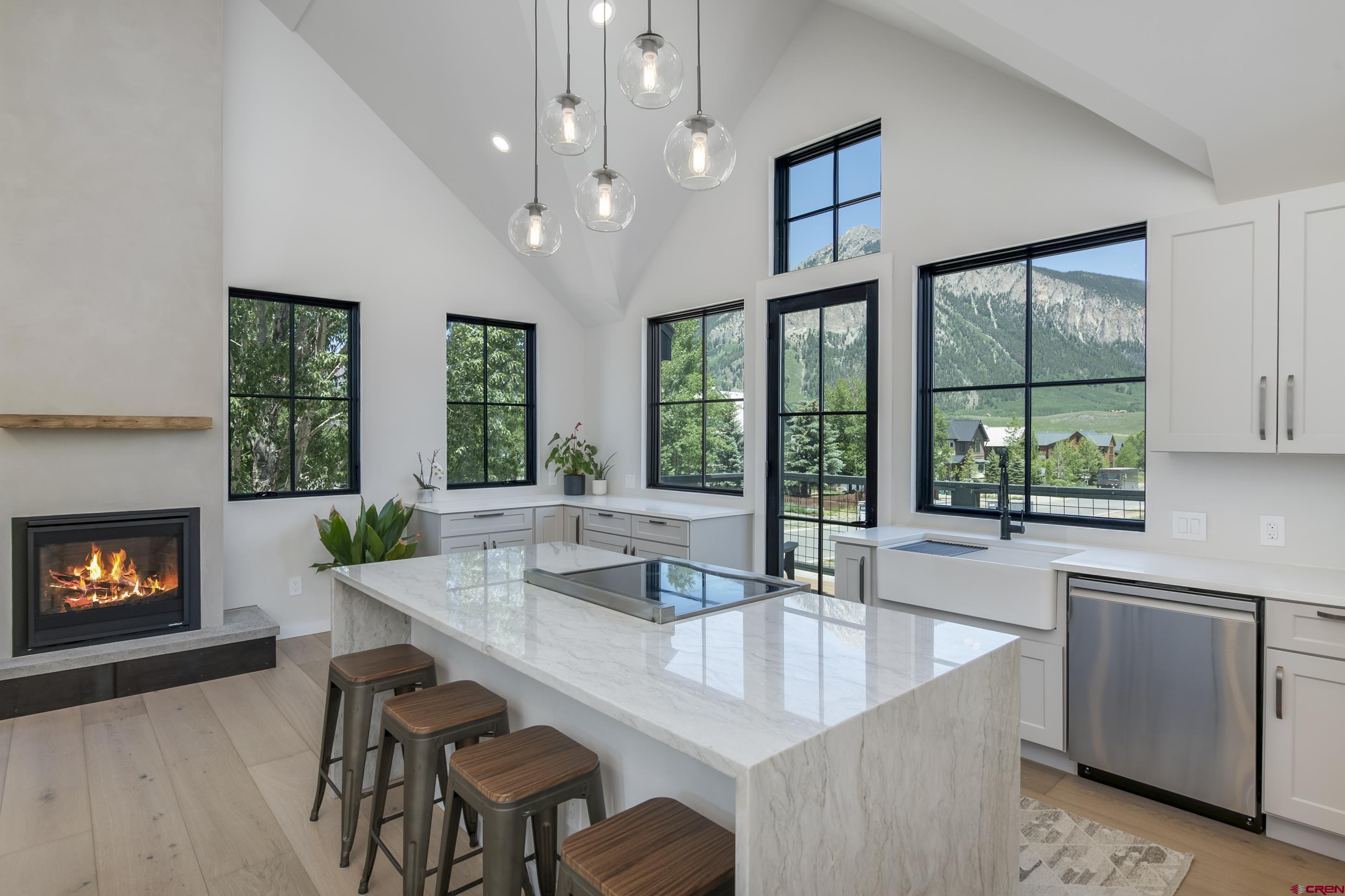 705 9th Street Crested Butte, CO 81224 - Photo 3 of 44 a dining room with furniture a fireplace and large windows